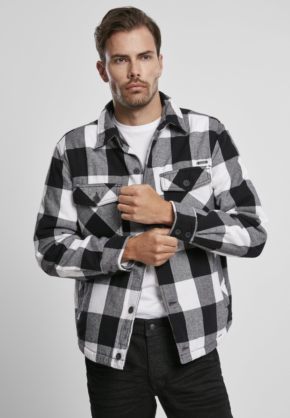 Man wearing a black and white checkered shirt on a gray background
