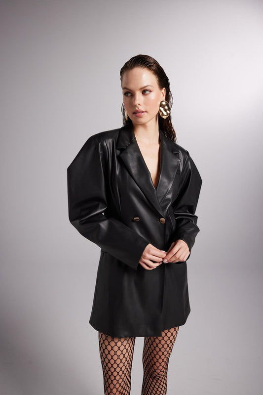 Woman wearing a black leather jacket on a gray background