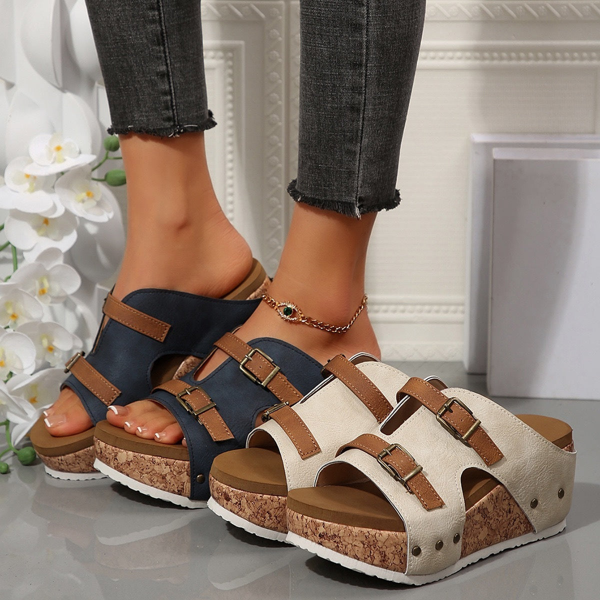 Two pairs of sandals, one black and one beige, worn on feet with a neutral background.