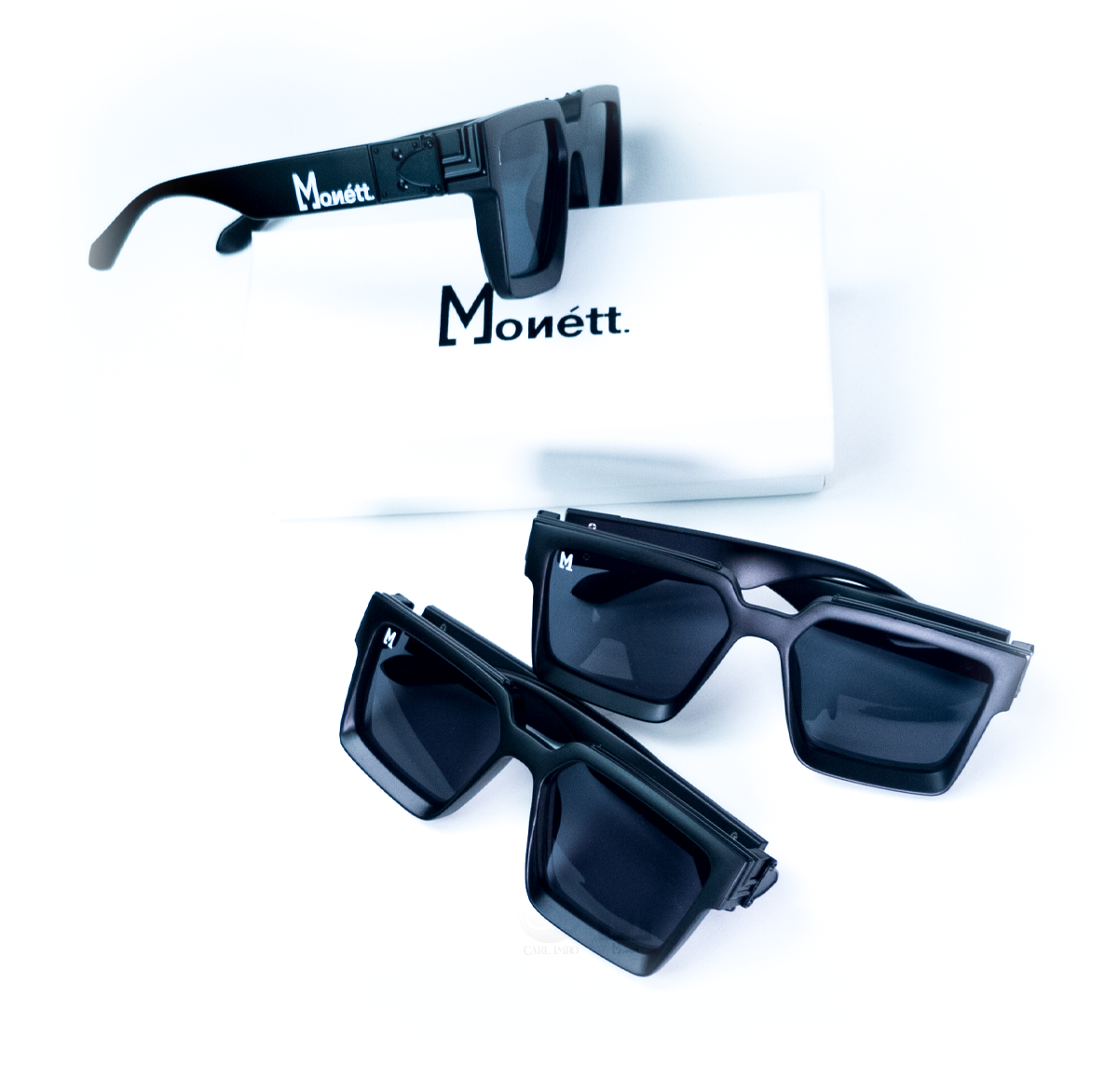 Black sunglasses with 'Monett' branding on a white background
