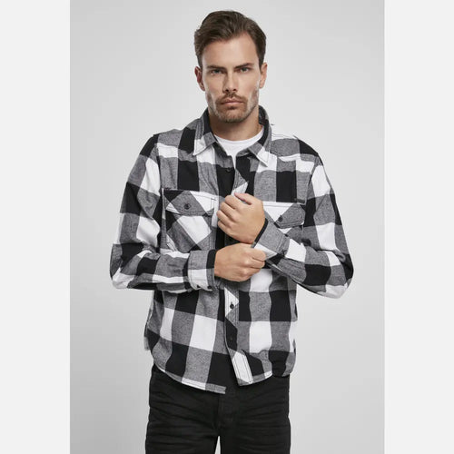 Man wearing a black and white checkered shirt against a plain background