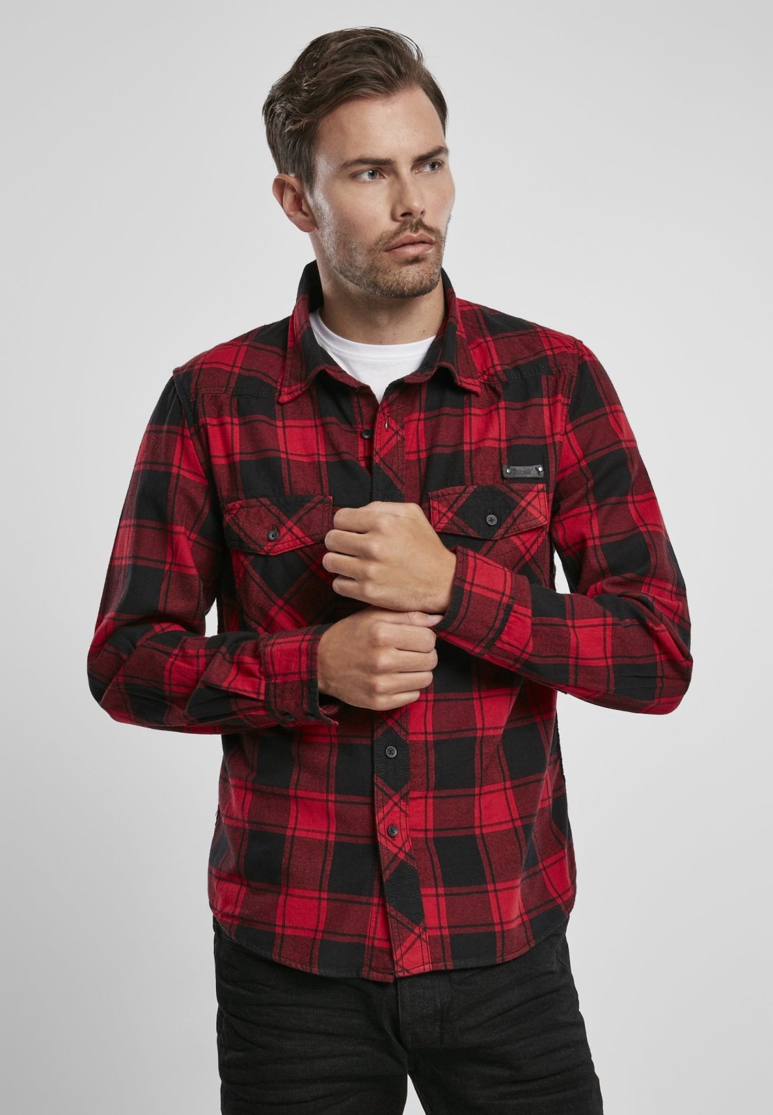 Man wearing a red and black plaid shirt on a white background