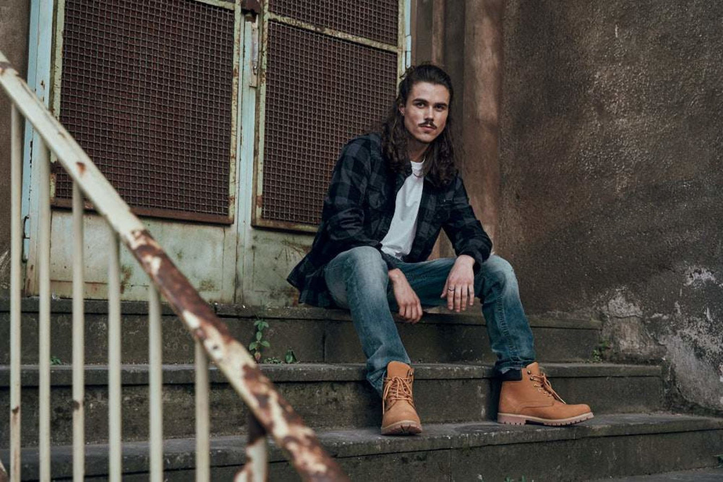 Man sitting on a set of stairs in an urban setting
