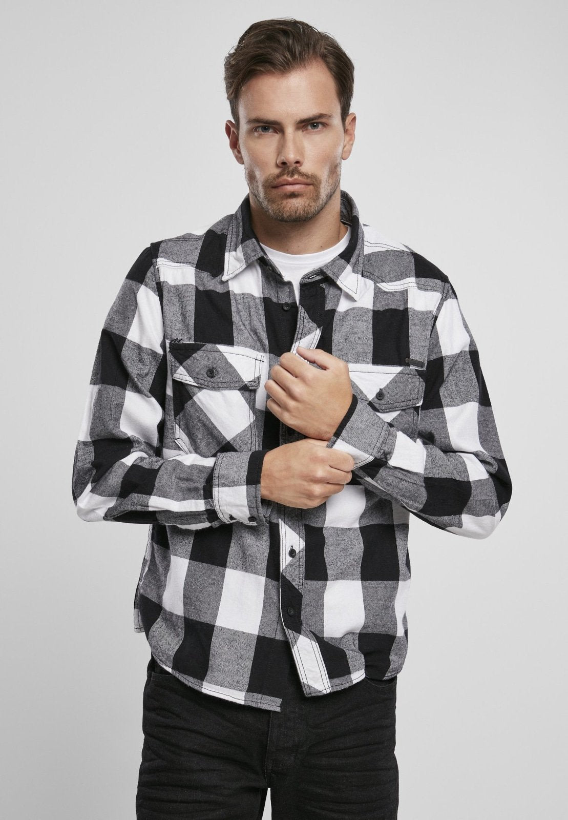 Man wearing a black and white checkered shirt against a plain background