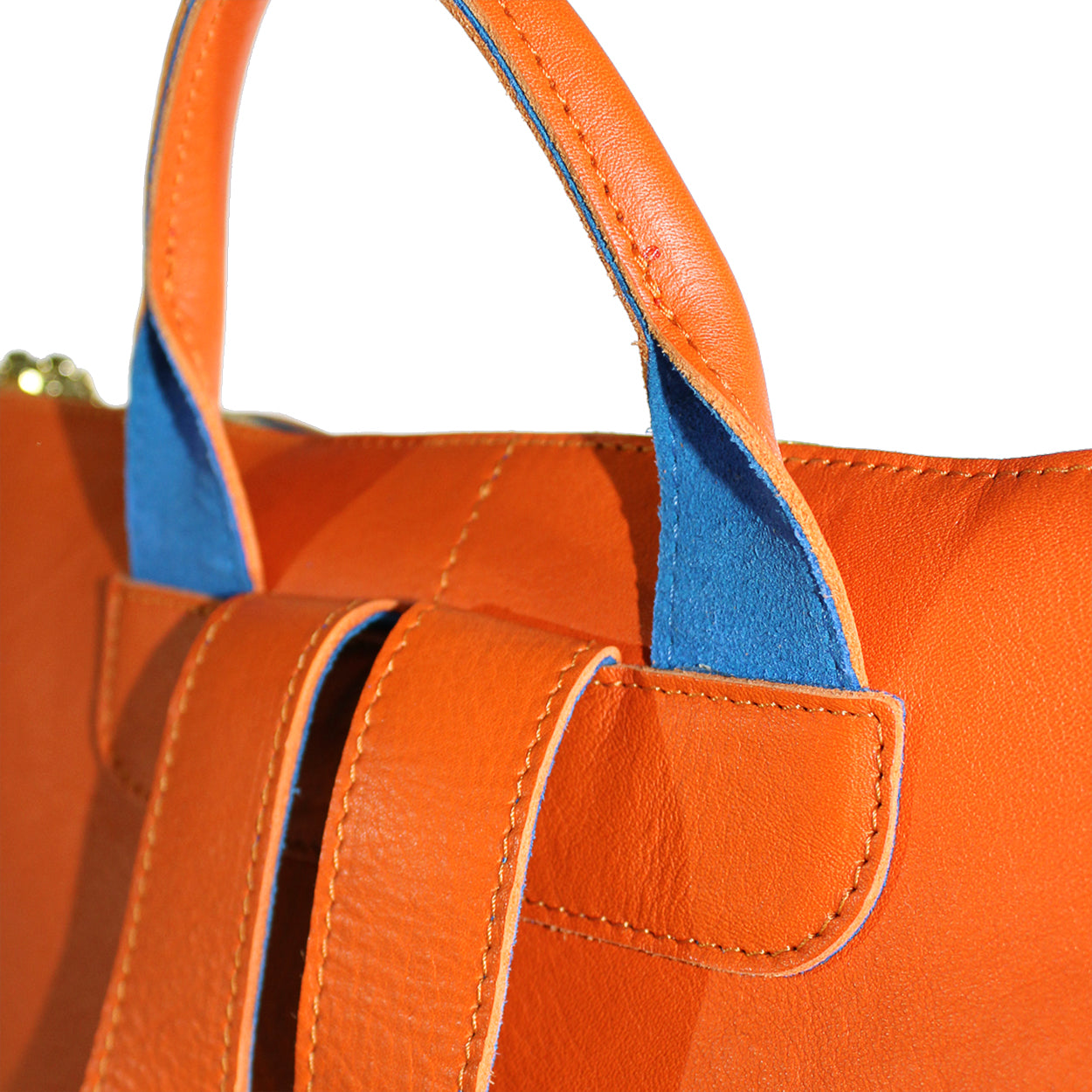 Close-up of an orange leather handbag with blue interior lining.