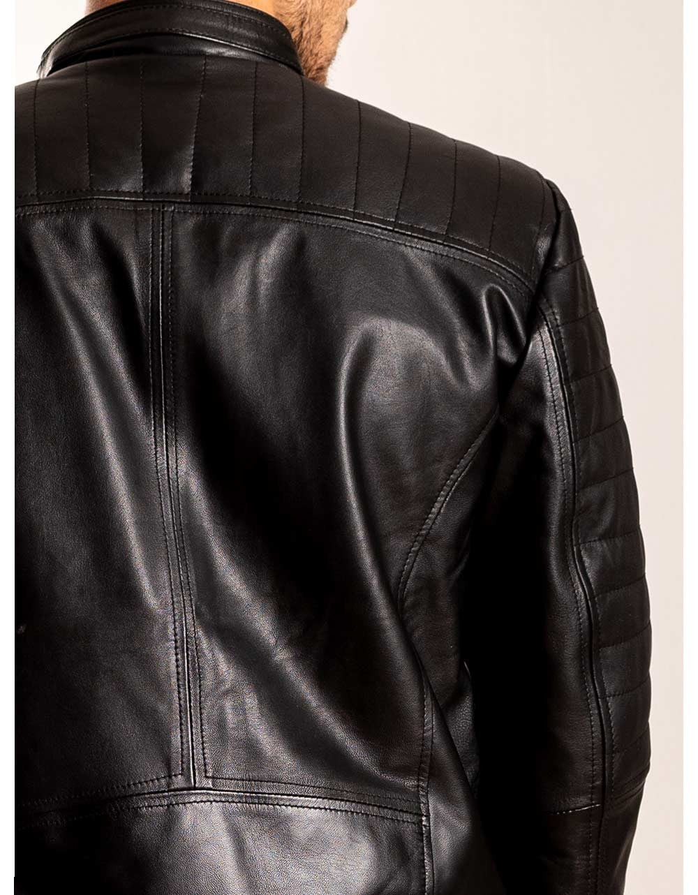 Black leather jacket worn by a person on a plain background