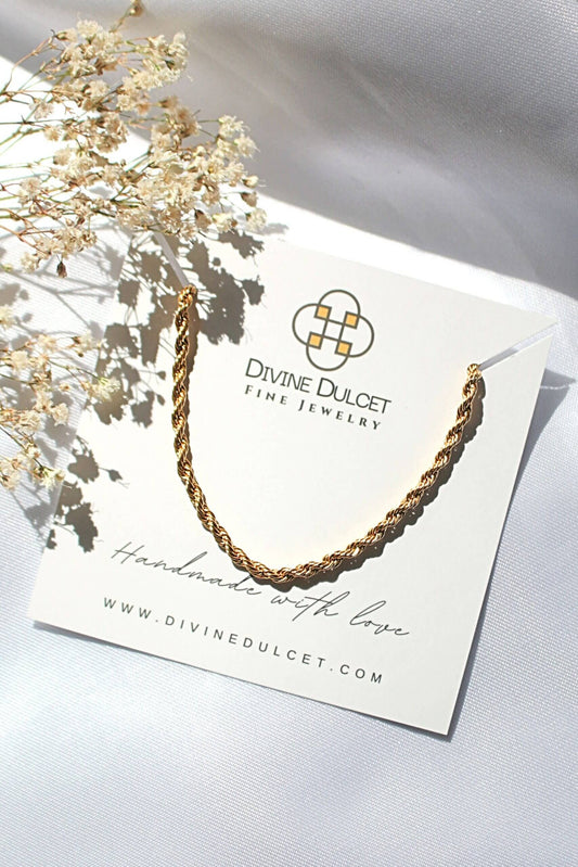 Gold necklace on a Divine Dulcet jewelry card with dried flowers.