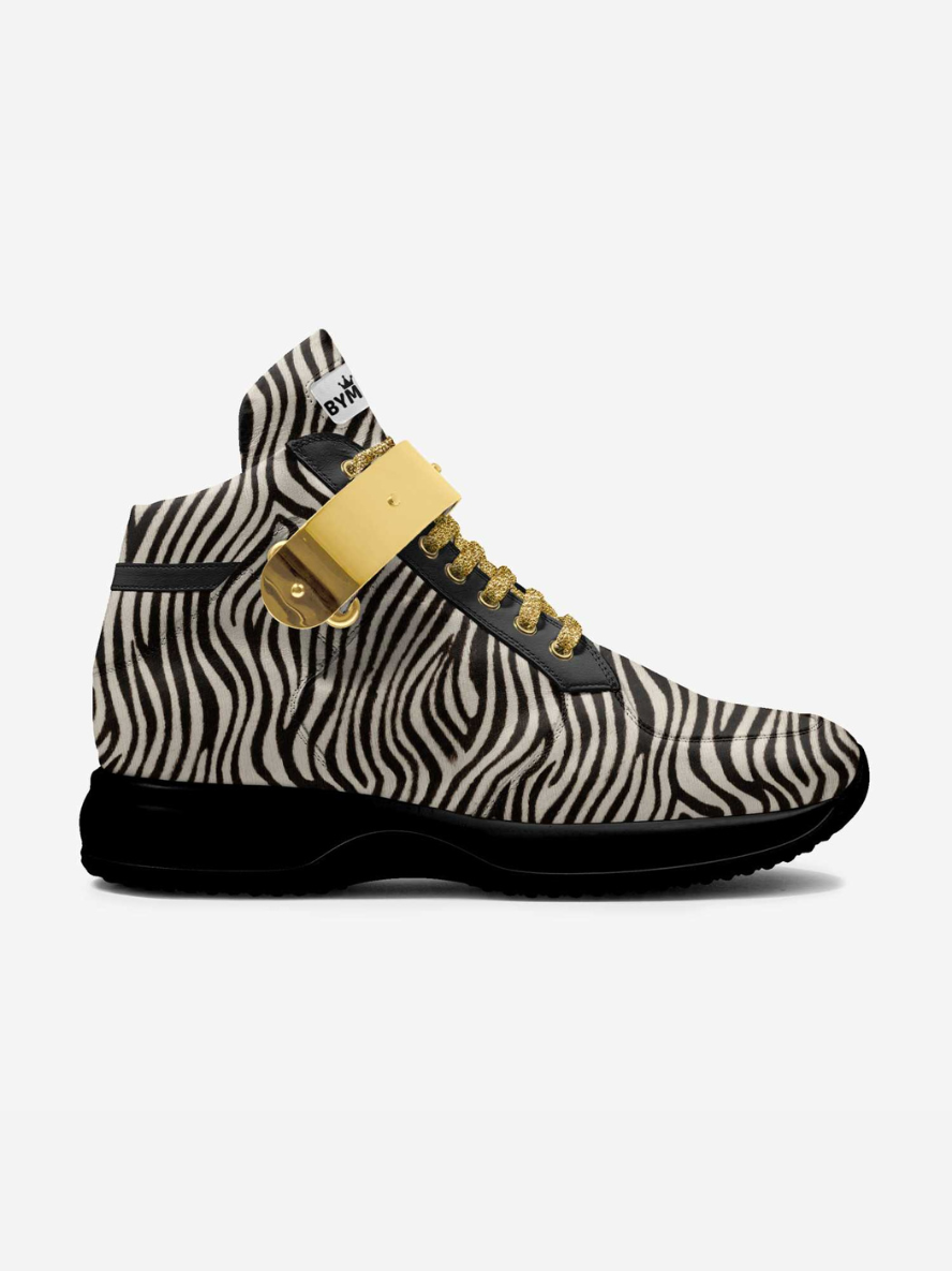 Zebra-patterned sneaker with gold accents on a white background
