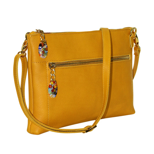 Yellow handbag with decorative charms on a white background