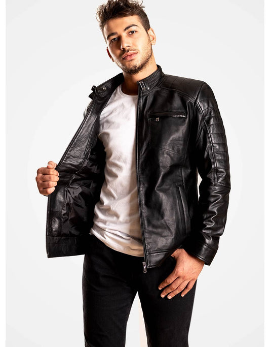 Man wearing a black leather jacket over a white shirt on a white background