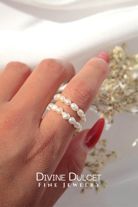 Hand wearing a pearl ring with 'Divine Dulcet Fine Jewelry' branding.