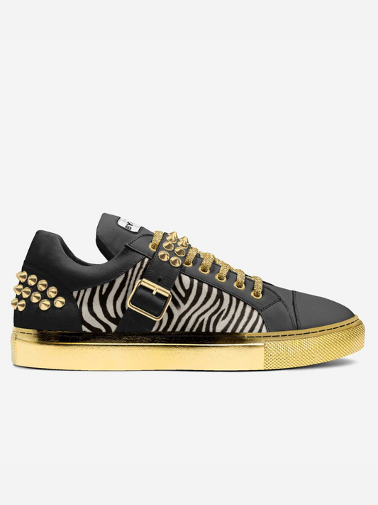 Black sneaker with gold accents and zebra pattern on a white background