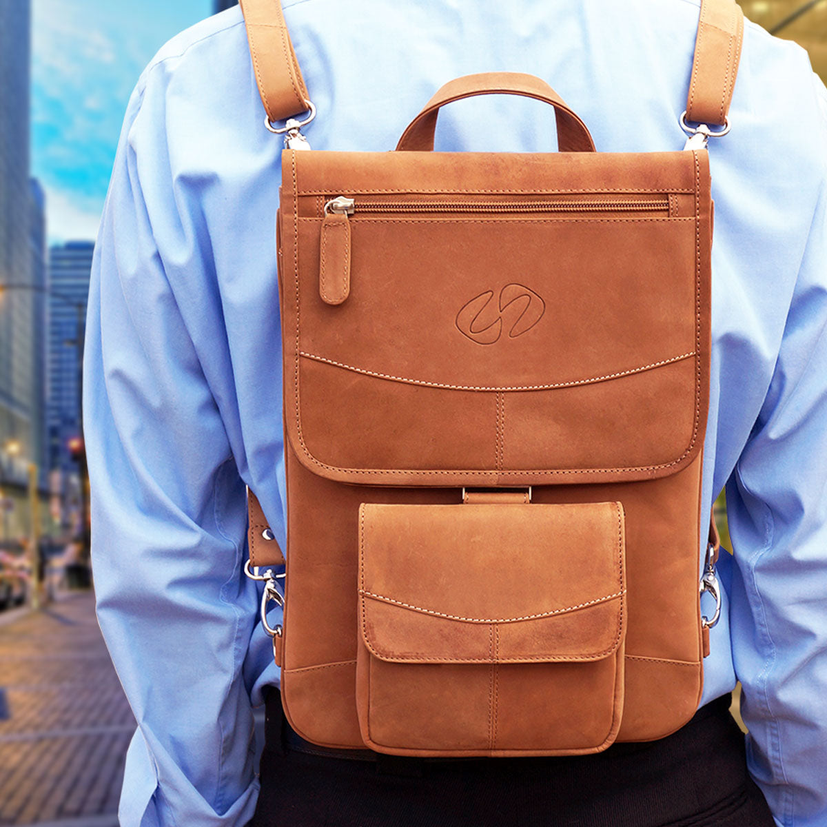 Brown leather backpack worn by a person on a city street