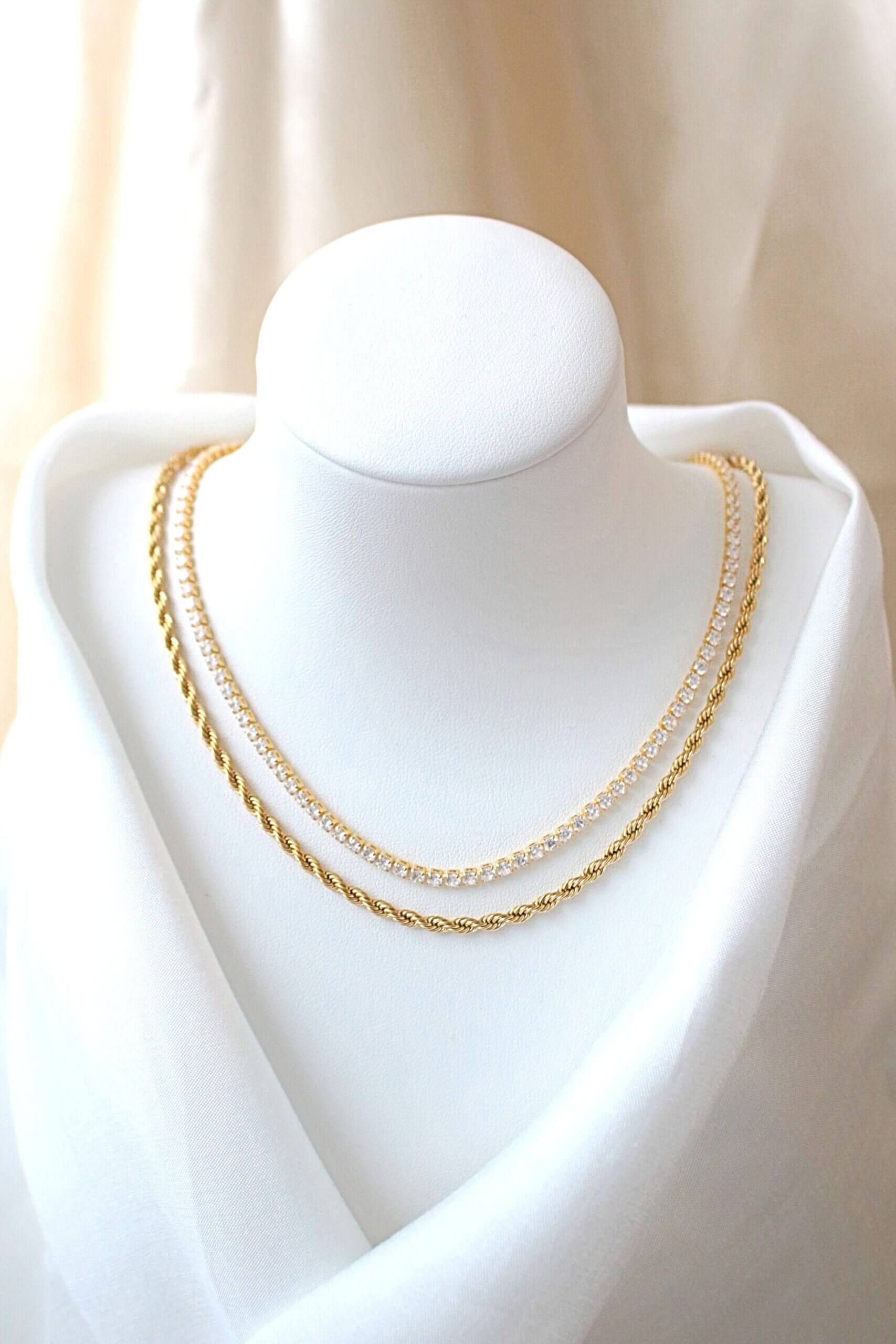 Gold chain necklace on a mannequin bust against a neutral background