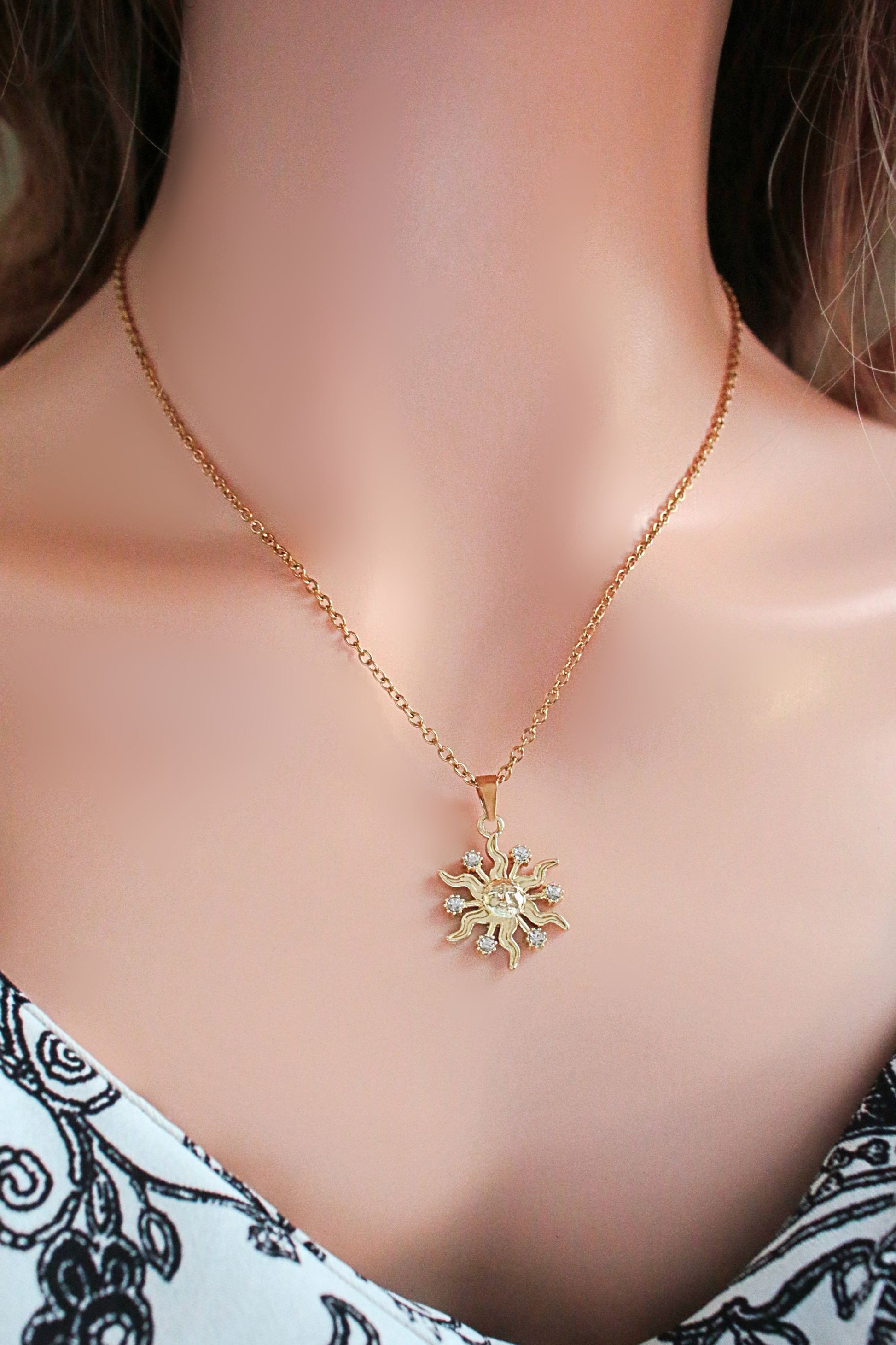 Gold necklace with a sunflower pendant on a mannequin