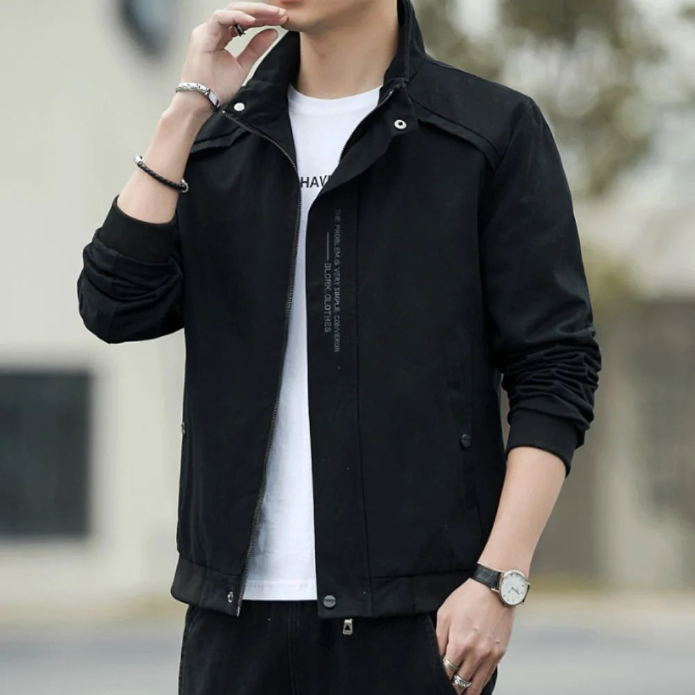 Person wearing a black jacket over a white shirt with a blurred background