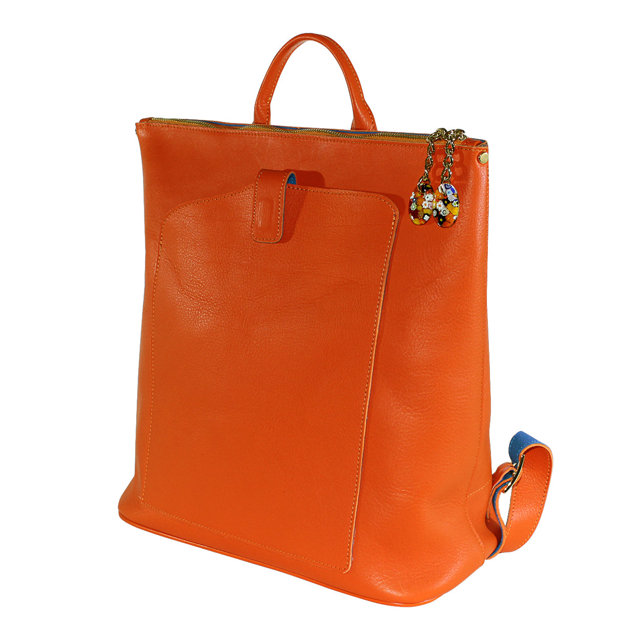 Orange leather backpack with a decorative charm on a white background