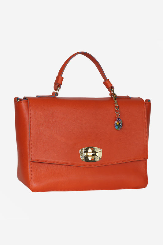 Orange handbag with a decorative clasp on a white background