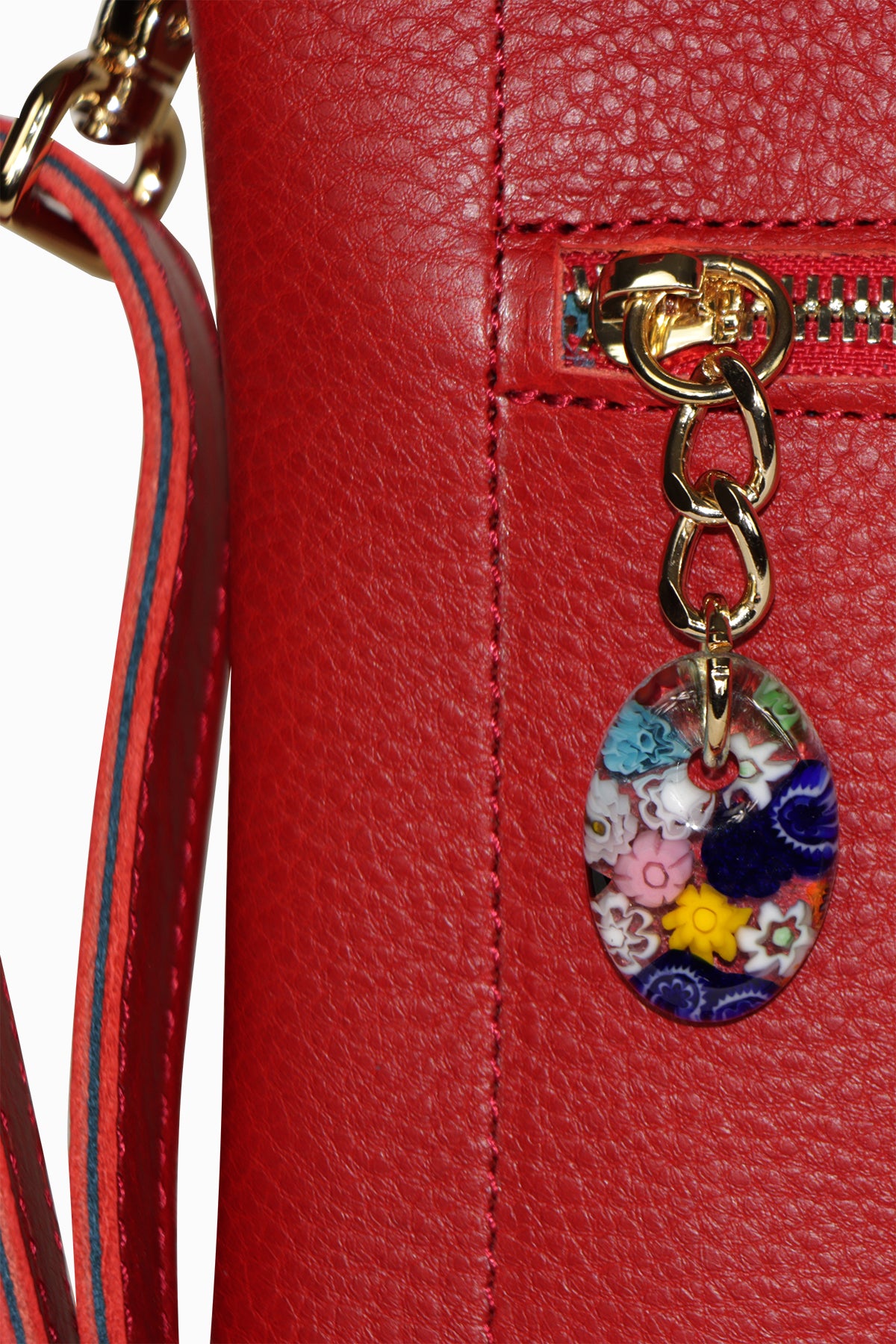 Red leather handbag with a colorful charm on a white background