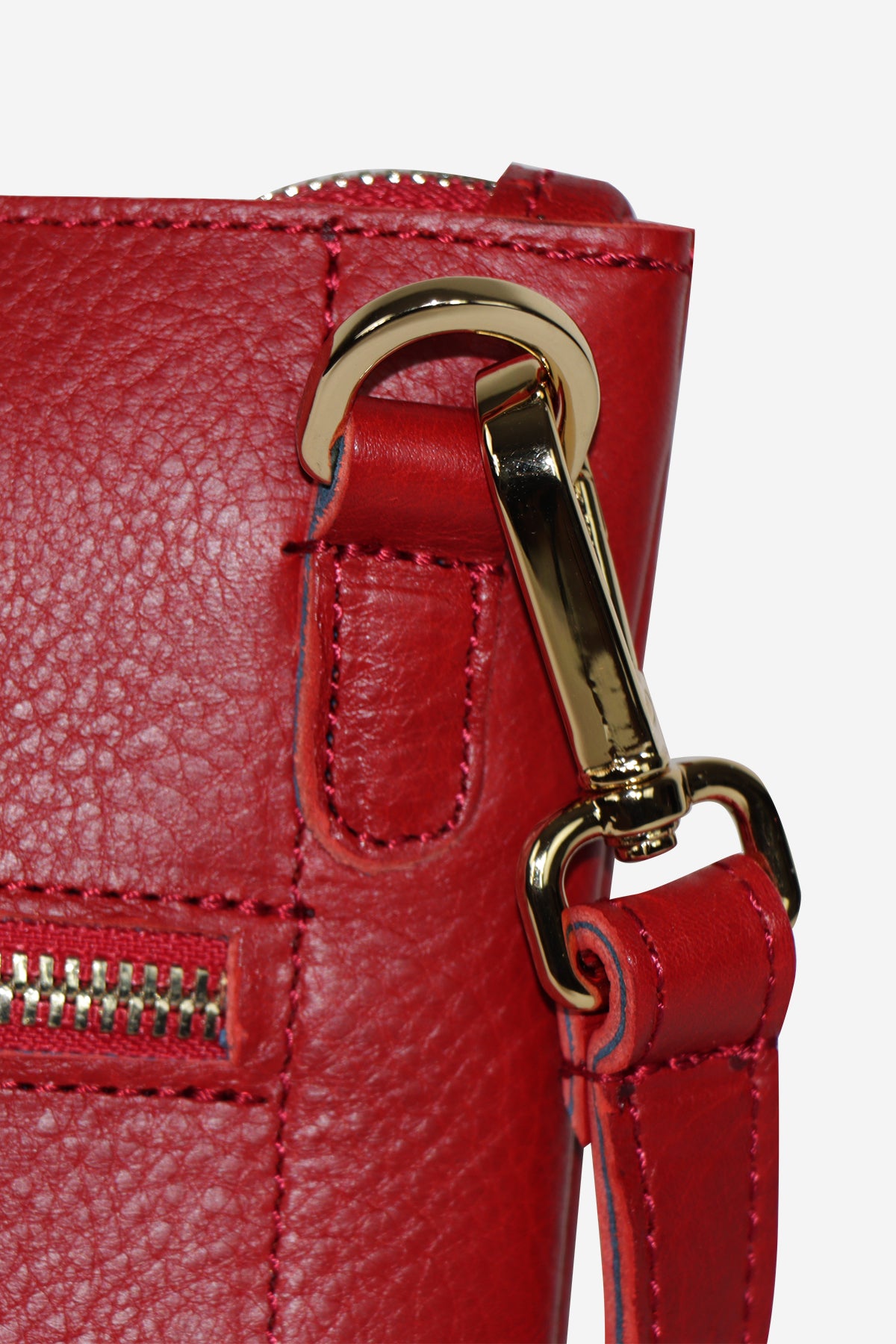 Close-up of a red leather handbag with a gold clasp on a white background