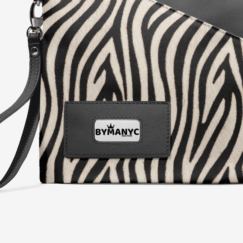 Zebra patterned clutch with 'BY MANYC' logo on a white background