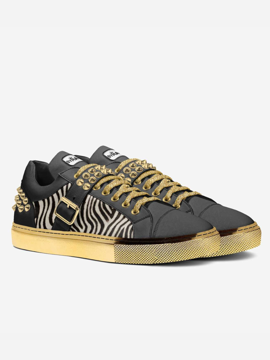Black and gold sneaker with zebra pattern on a white background