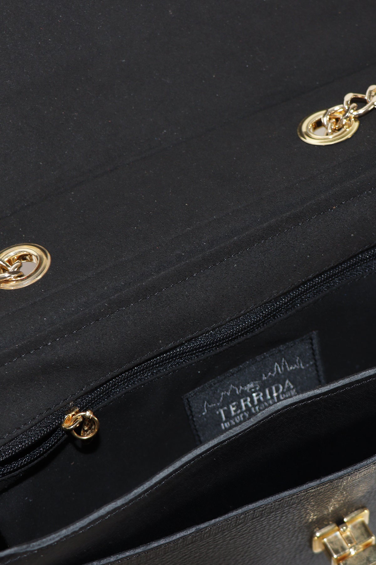 Close-up of a black handbag with gold hardware