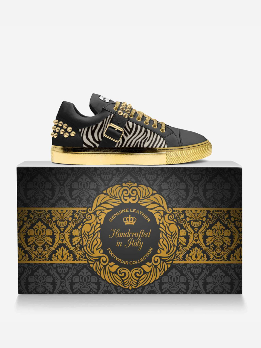 Black and gold sneaker with zebra pattern on a decorative box