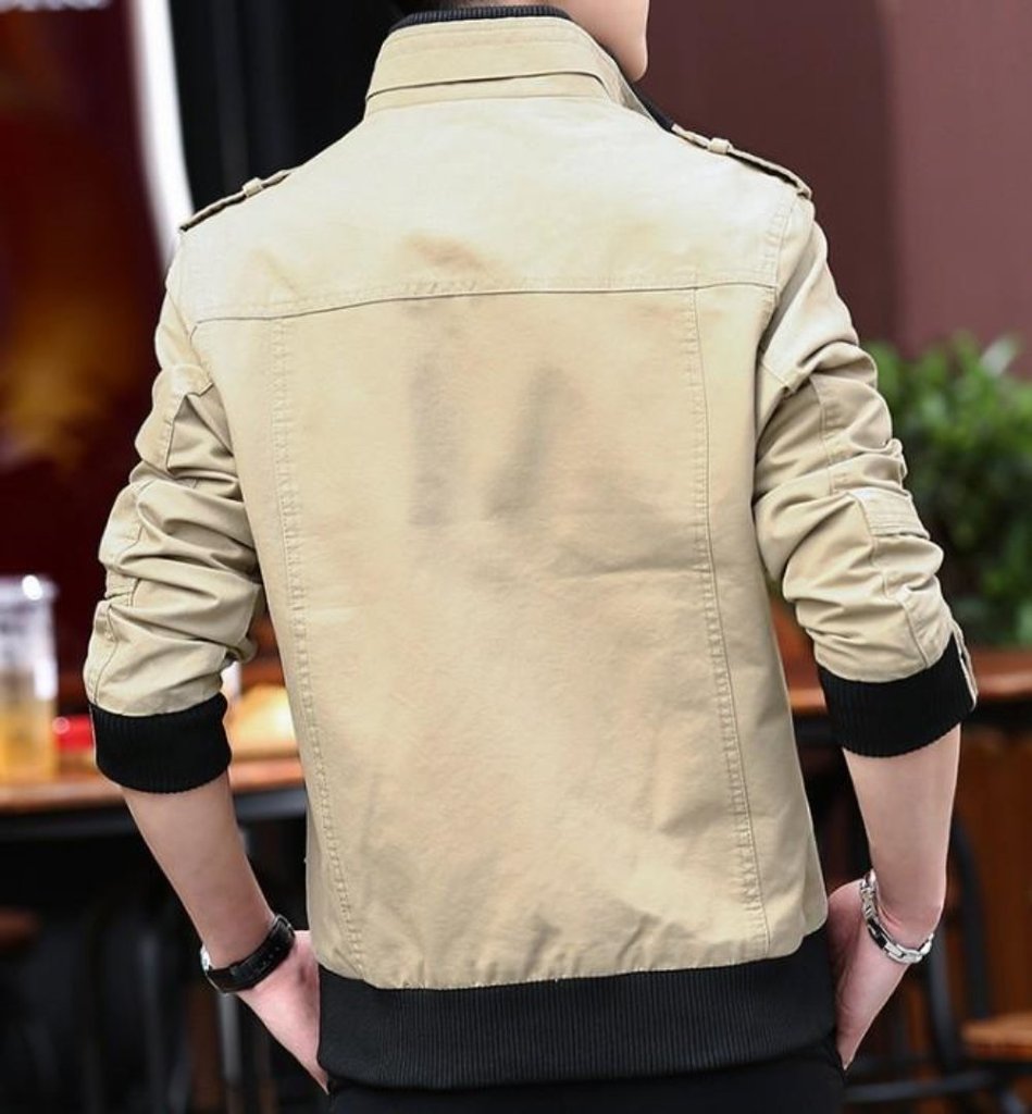 Beige jacket worn by a person with a blurred indoor background