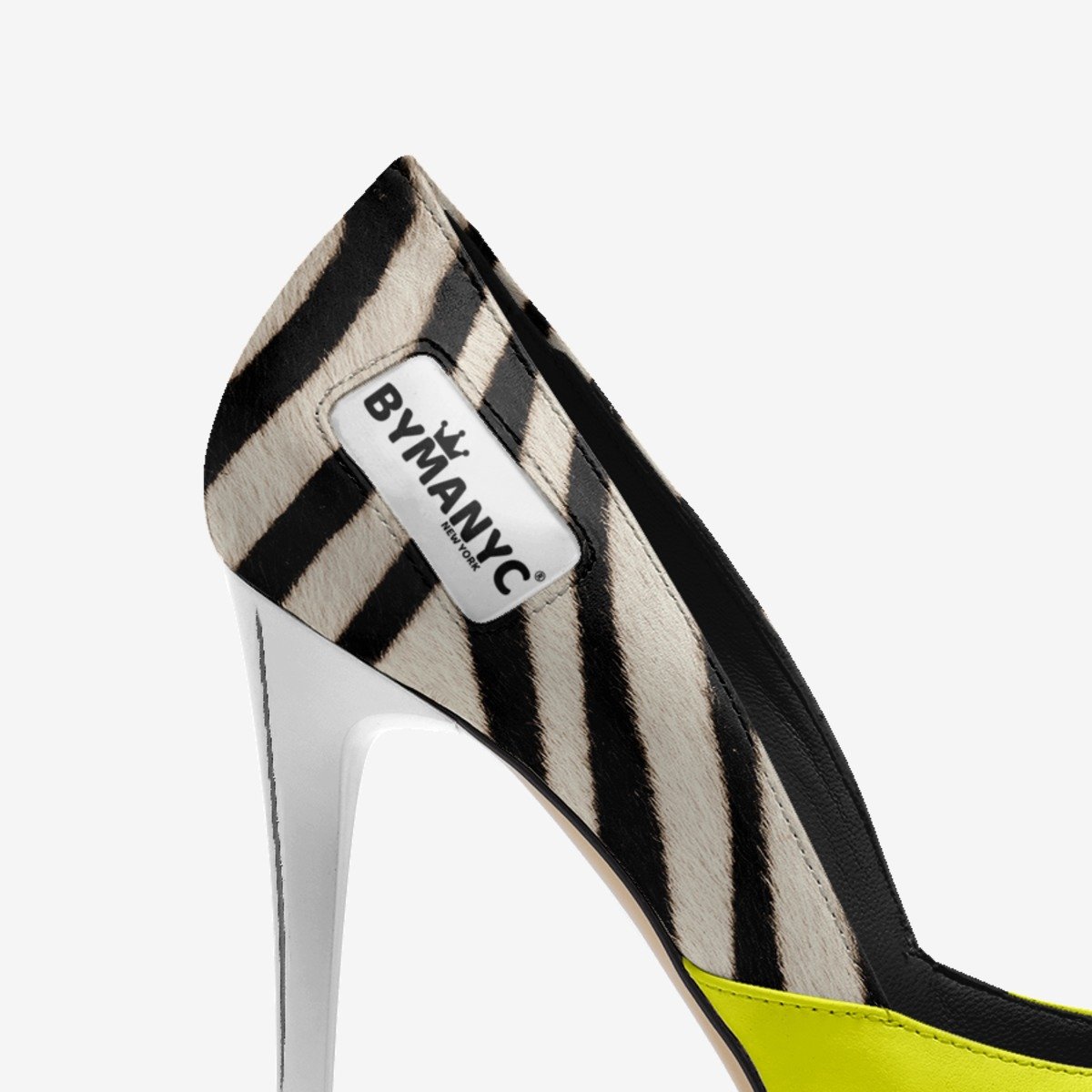 High-heeled shoe with zebra pattern and 'Bymanyc' label on a white background