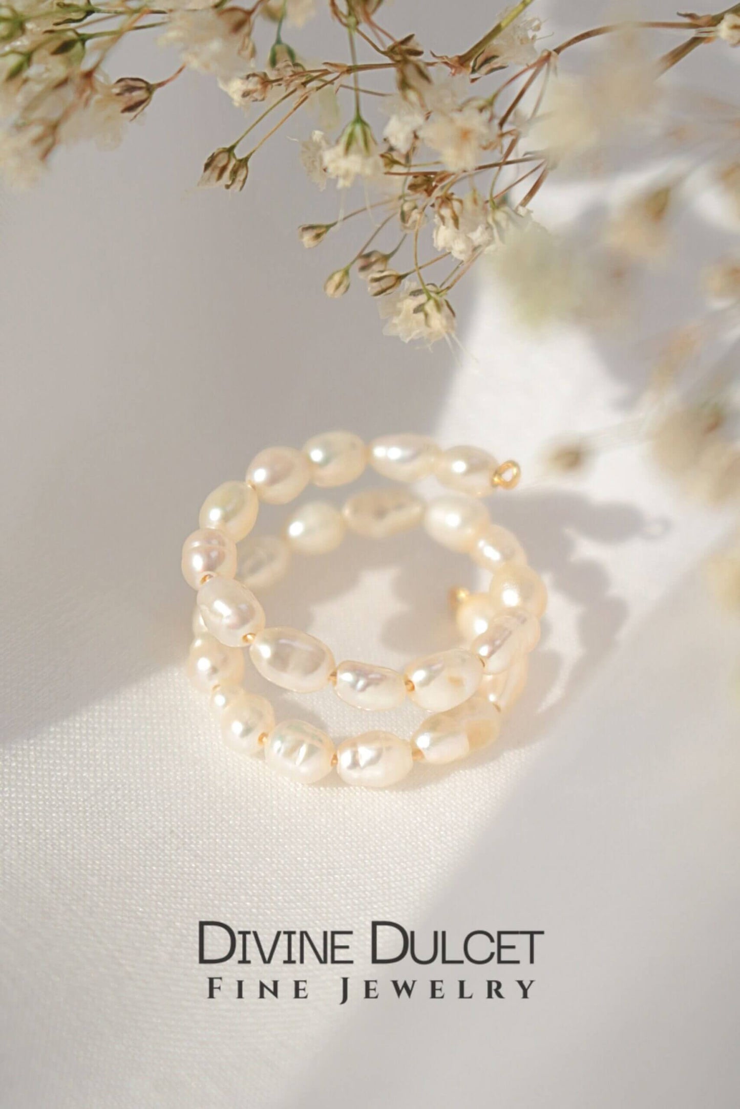 Pearl ring on a light surface with 'Divine Dulcet Fine Jewelry' branding.