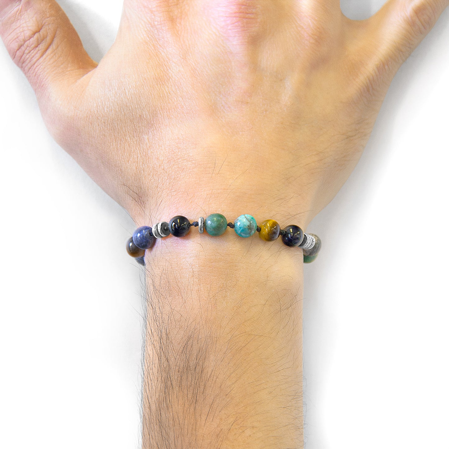 Multicolored beaded bracelet on a wrist against a white background
