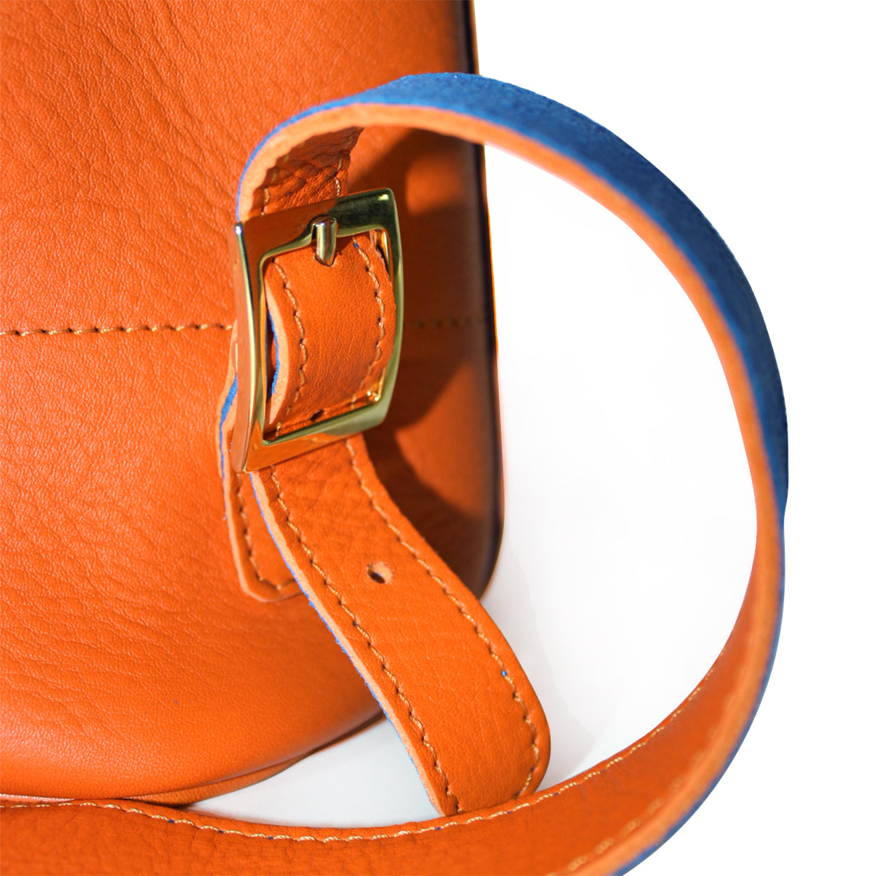Close-up of an orange leather bag with a gold buckle on a white background