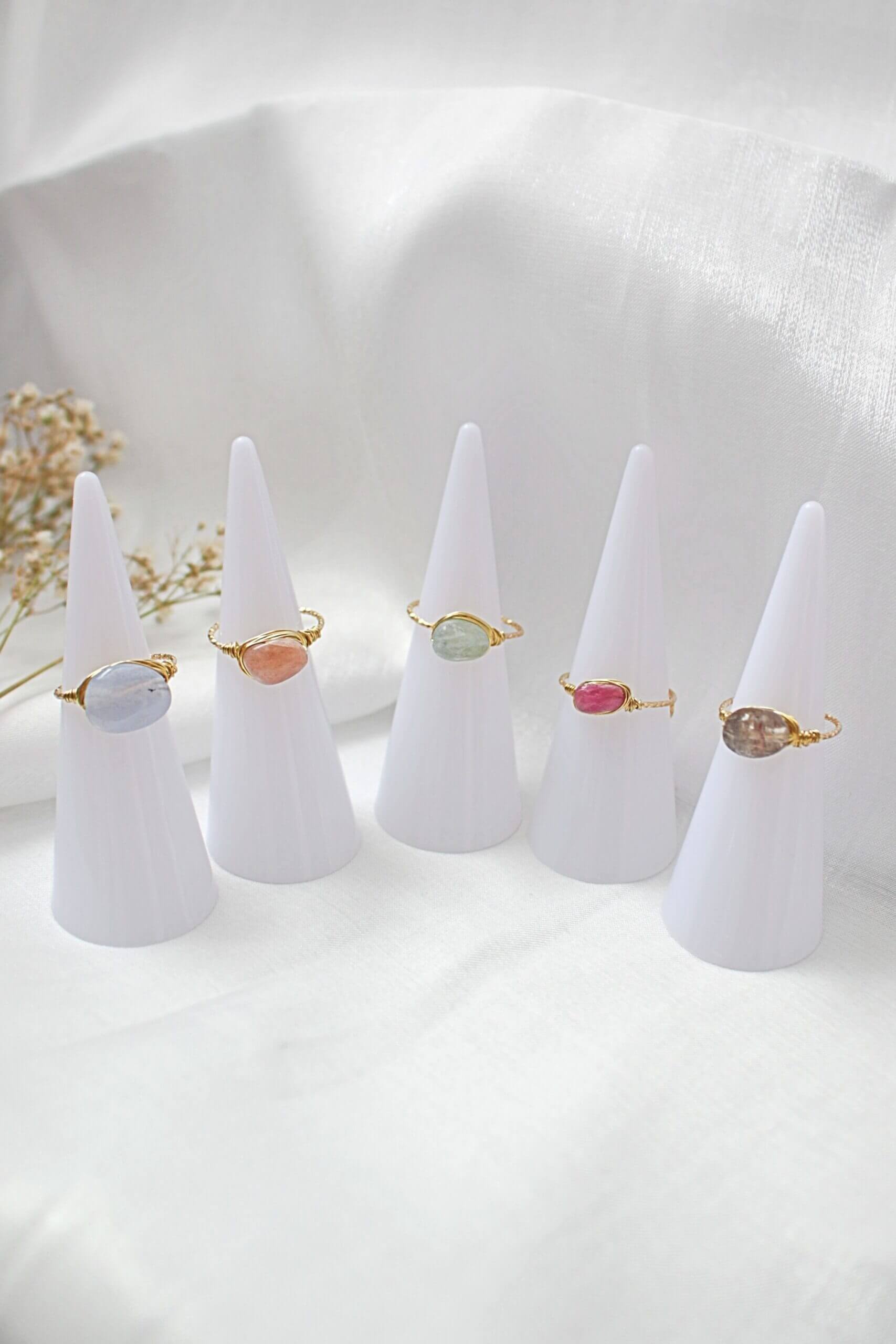 Set of five rings on white cone stands against a white background