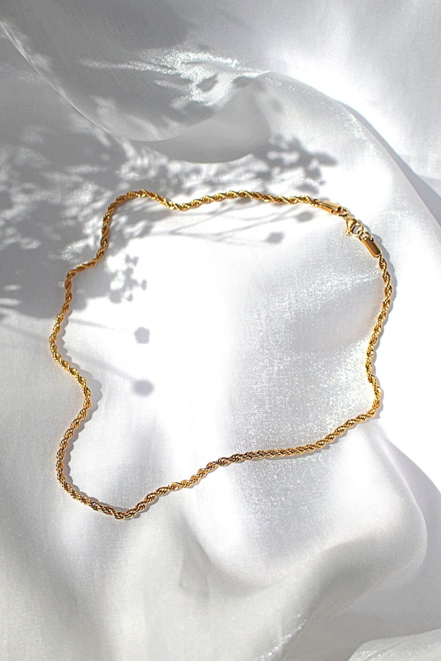 Gold necklace on a white fabric background