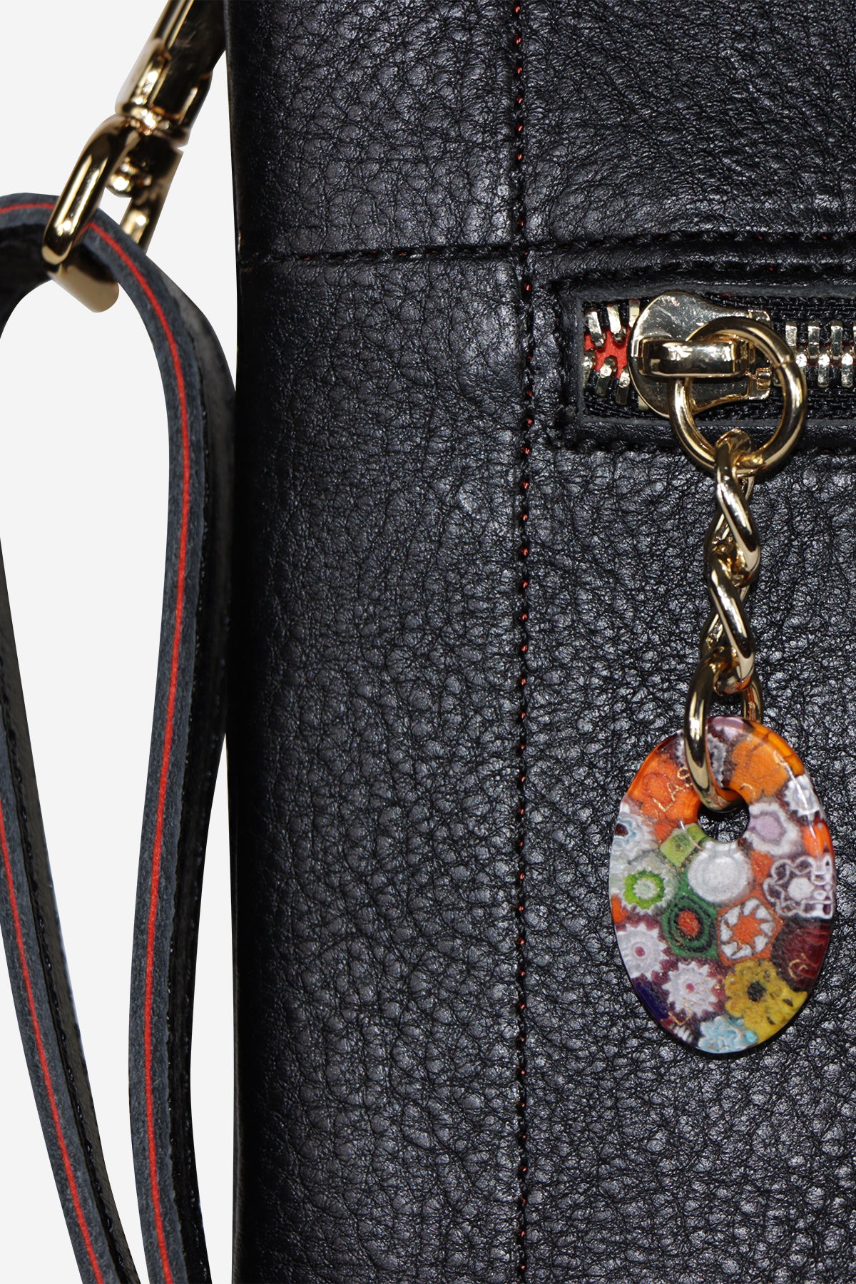 Black textured handbag with a colorful floral charm on a white background