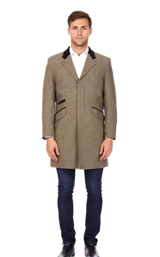 Man wearing a brown overcoat with a white shirt and dark pants on a white background