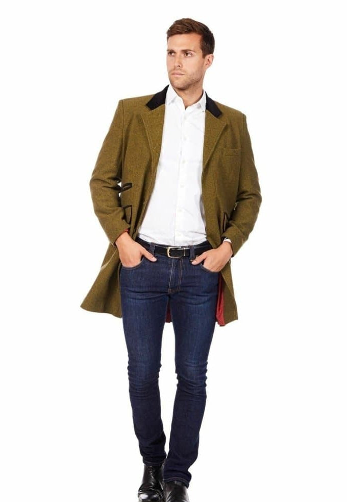 Man wearing a green coat, white shirt, and blue jeans on a white background