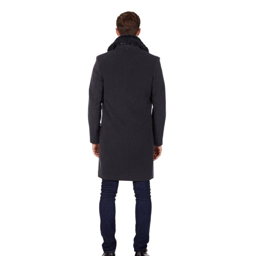 Man wearing a long dark coat from behind on a white background