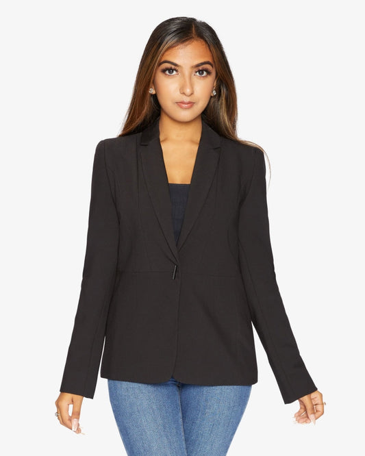 Woman wearing a black blazer over a blue top on a white background