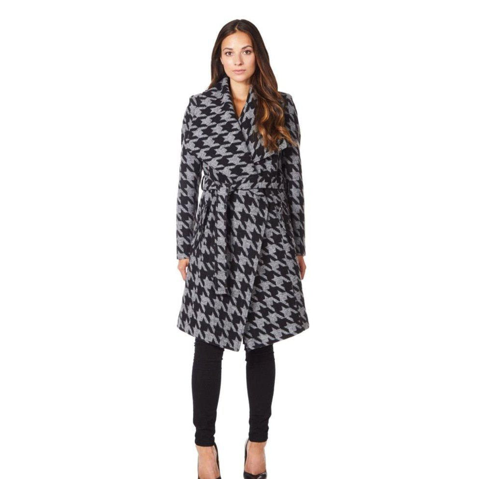 Woman wearing a houndstooth patterned coat on a white background