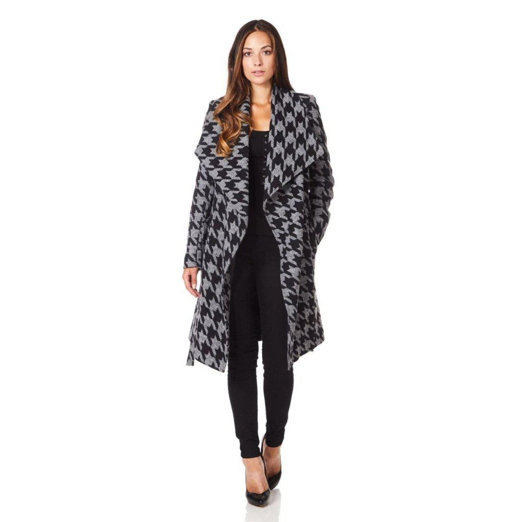 Woman wearing a houndstooth patterned coat on a white background