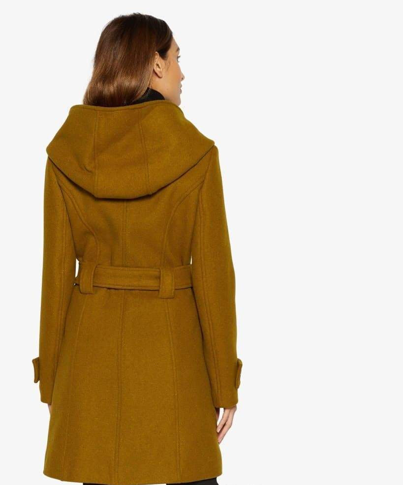 Woman wearing a mustard yellow coat with a hood on a white background.