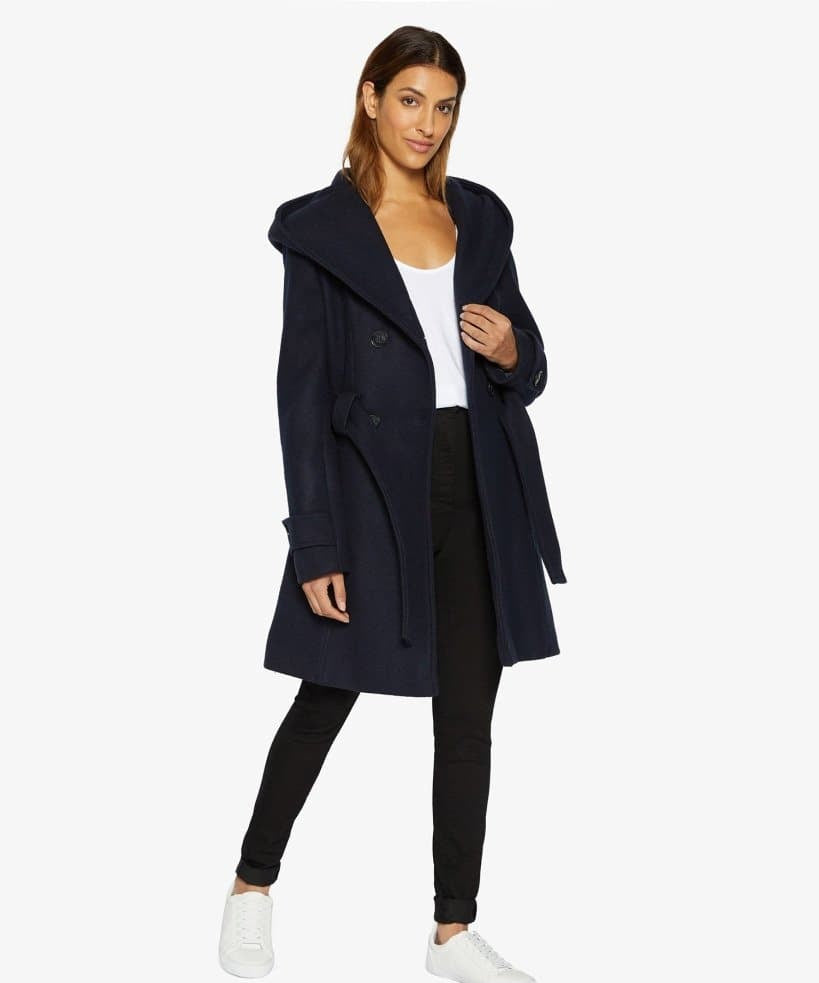 Woman wearing a navy coat on a white background.