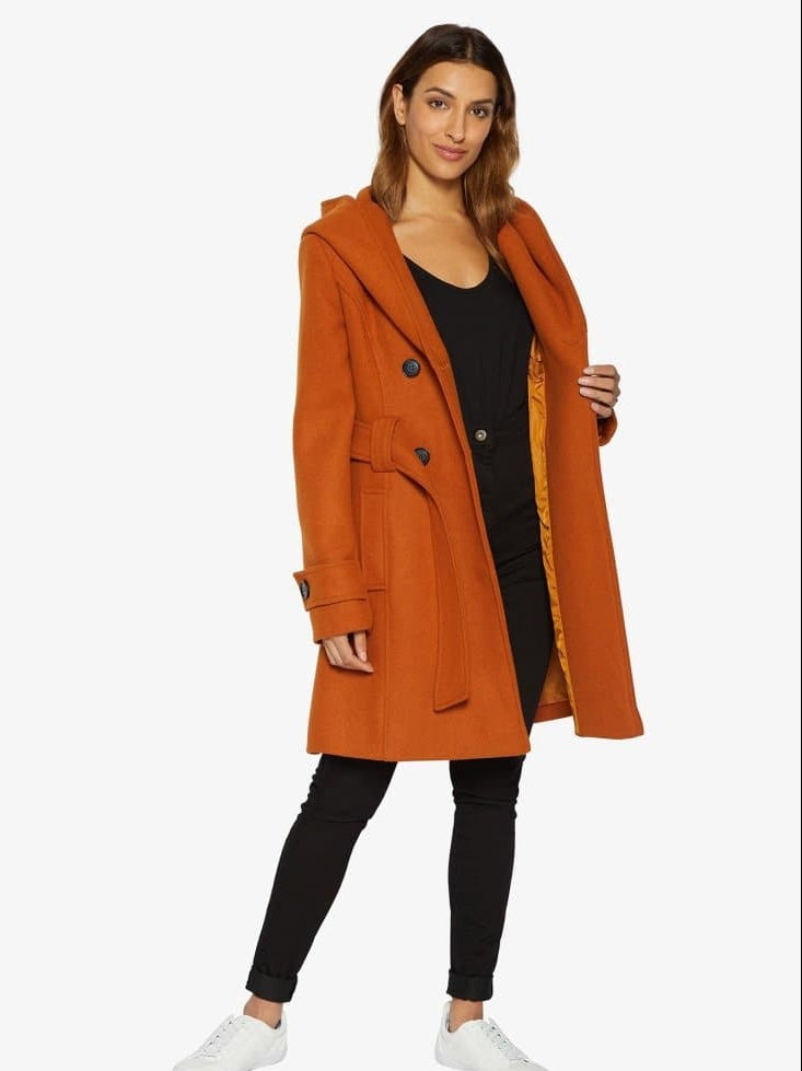 Woman wearing an orange coat on a white background.