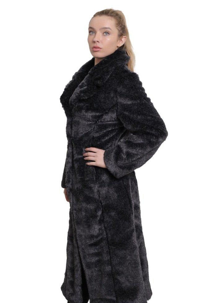 Woman wearing a long dark fur coat on a white background