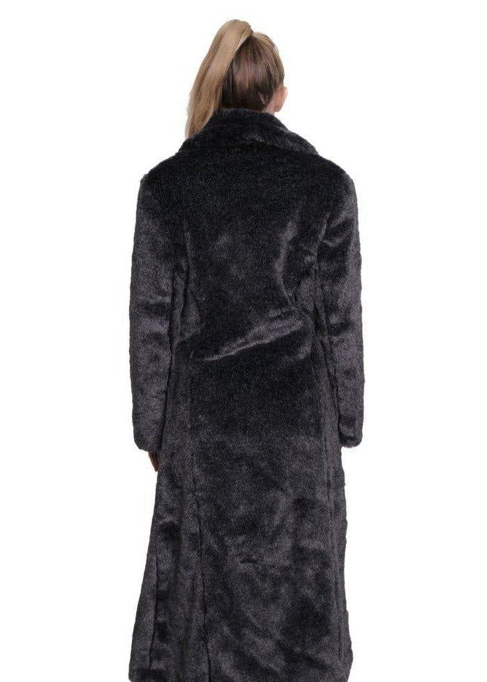 Woman wearing a long dark gray fur coat on a white background