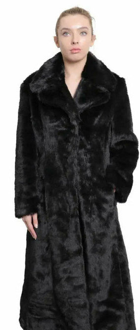 Woman wearing a long black fur coat with a visible brand logo on a white background