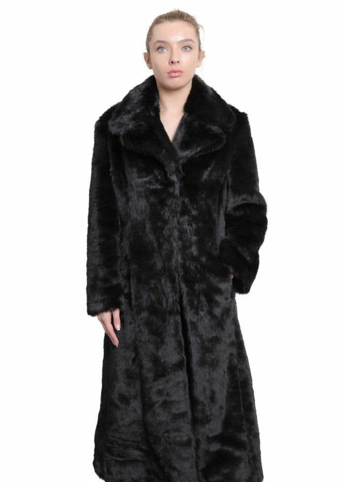 Woman wearing a long black fur coat on a white background