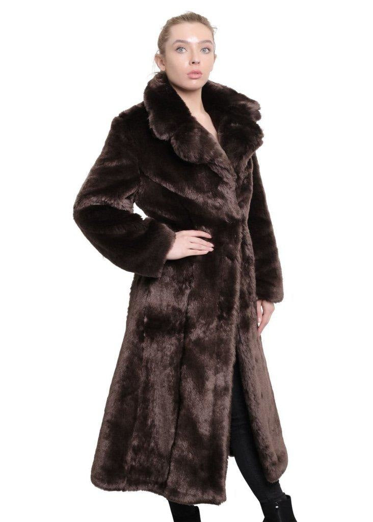 Woman wearing a long brown fur coat on a white background